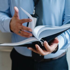 Buch_maskiert Ein Mann, der in einem Buch blättert.